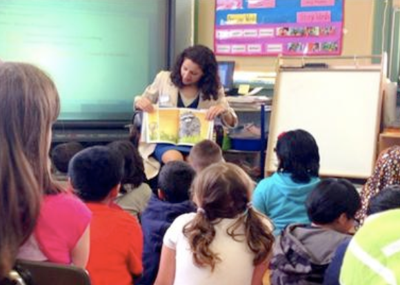A woman reading to a classroom of young children.