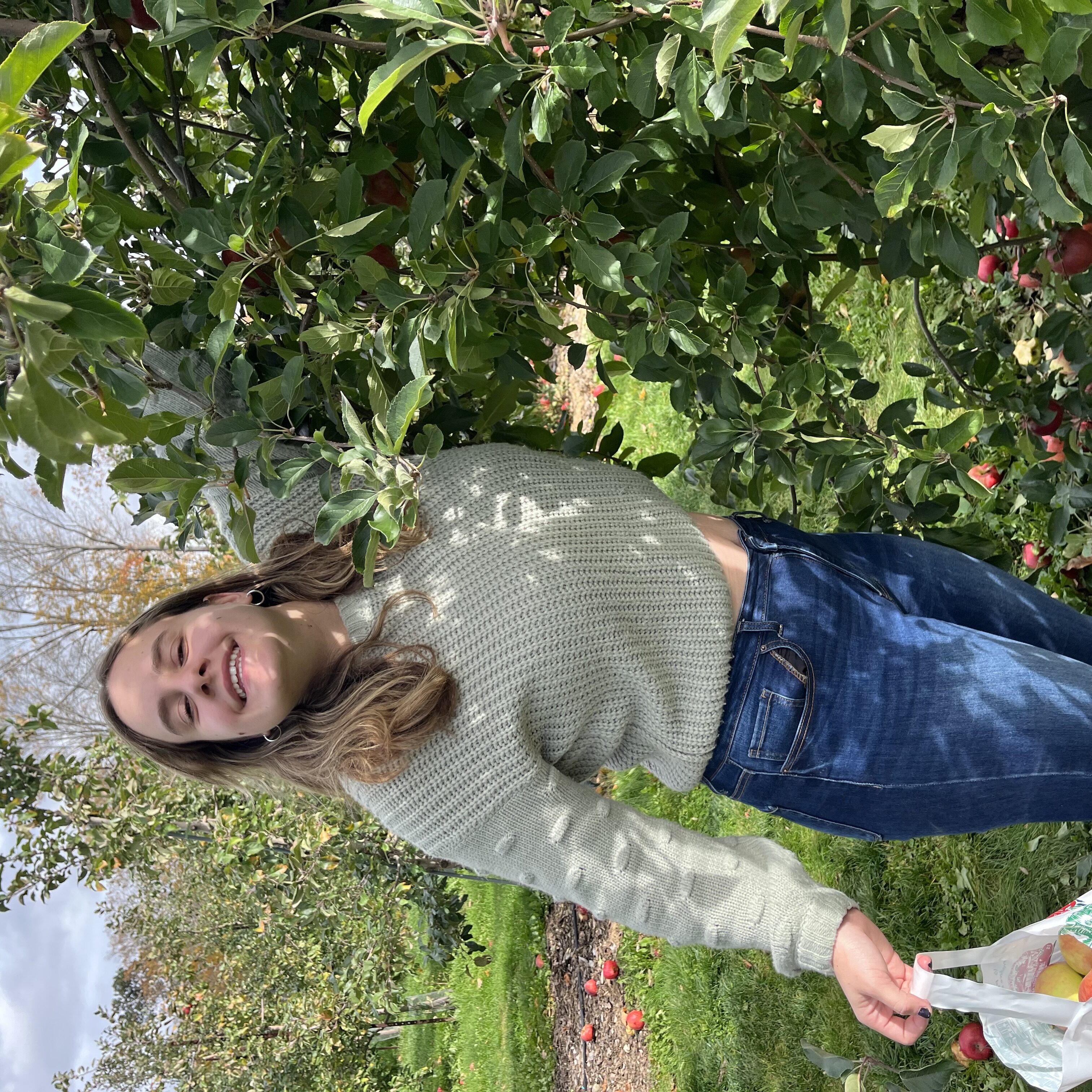 College-aged girl apple picking.